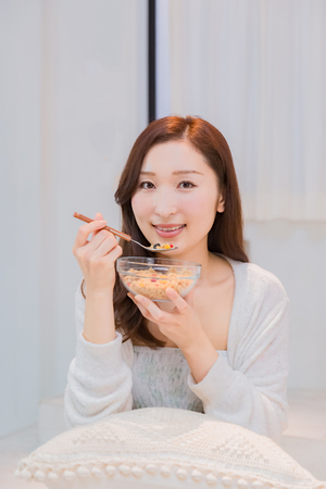 Lady in nightwear eating cerealsの写真素材