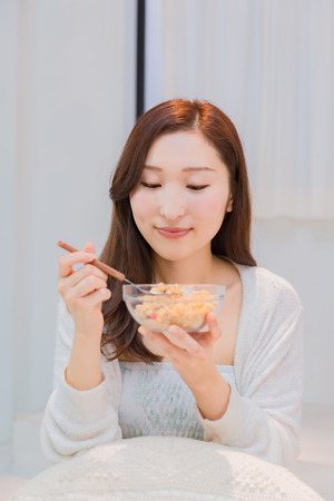Lady in nightwear eating cerealsの写真素材