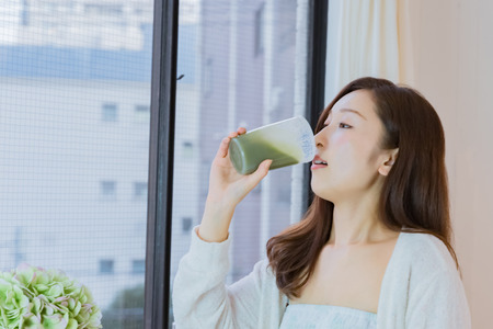 Lady drinking green smoothieの写真素材