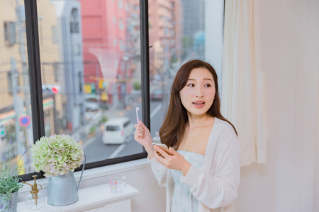 Lady looking at mobile smartphone brushing teethの写真素材
