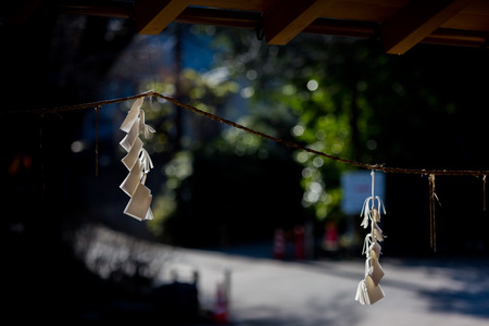 Straw rope with white zigzag paper strips, at the Shimenawa in Shinto Shrineの写真素材
