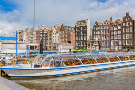 tour boat on canal in amsterdamの写真素材