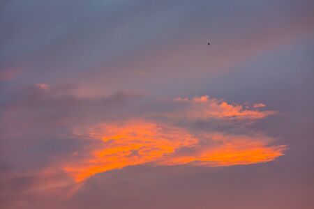 sunset sky with orange colored cloudの写真素材