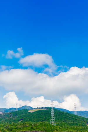 tower of electric transmission line with blue skyの写真素材