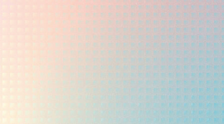 A soft, abstract background featuring a gentle gradient transitioning from a warm pastel pink to a cool pastel blue, overlaid with a subtle, repeating geometric dot pattern.の写真素材