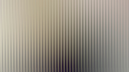 A close-up view of a textured surface with vertical ribs, creating a subtle play of light and shadow. The abstract pattern offers a clean, modern aesthetic suitable for various design applications.の写真素材