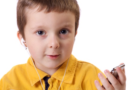 Cute little boy listening to music on a MP3 playerの写真素材