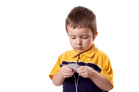 Cute little boy listening to music on a MP3 playerの写真素材
