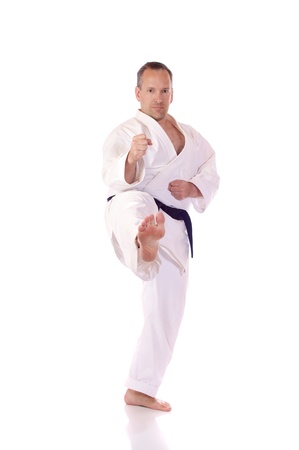 Man in karate-gi doing a front kickの写真素材
