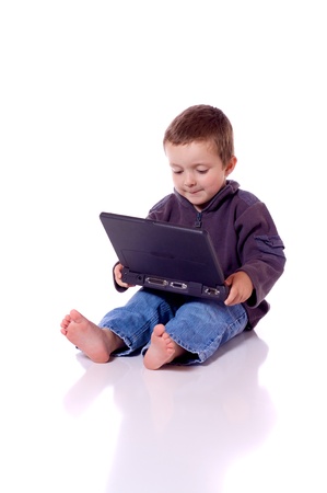 Cute little boy sitting with a laptopの写真素材