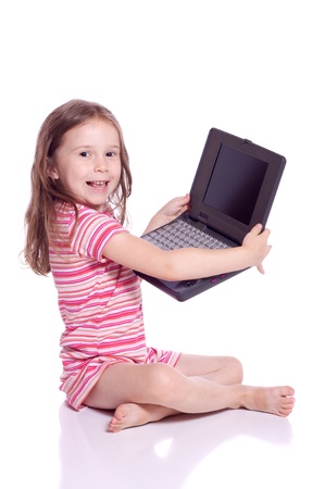 Cute little girl sitting with a laptopの写真素材
