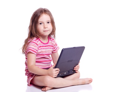 Cute little girl sitting with a laptopの写真素材