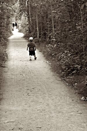 Little boy walking in a forest pathの写真素材