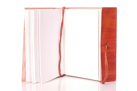 Old leather-bound book with parchment paper inside on a white backgroundの写真素材