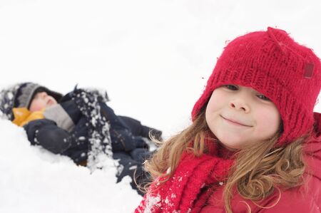 Brother and sister playing in the snowの写真素材