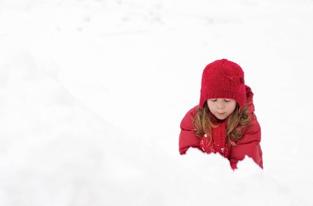 Cute little girl playing in the snowの写真素材