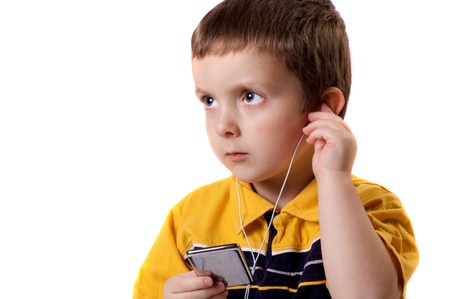 Cute little boy listening to music on a MP3 playerの写真素材