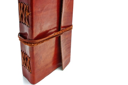 Old leather-bound book with parchment paper inside on a white backgroundの写真素材