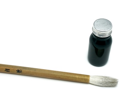 Black chinese/japanese symbol with a calligraphy brush resting nearby. This is a close macro shot with very low depth of field. The japanese form is pronounced DO and means The Way.の写真素材
