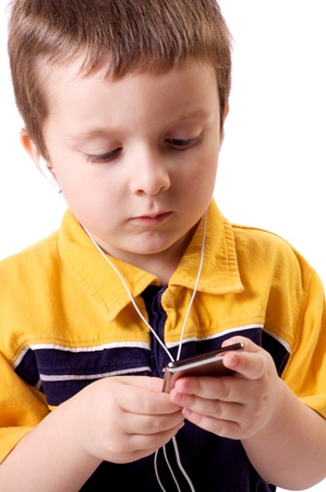 Cute little boy listening to music on a MP3 playerの写真素材