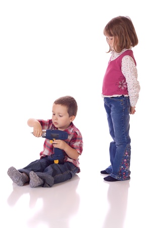 Cute little girl watching his brother with a drillの写真素材