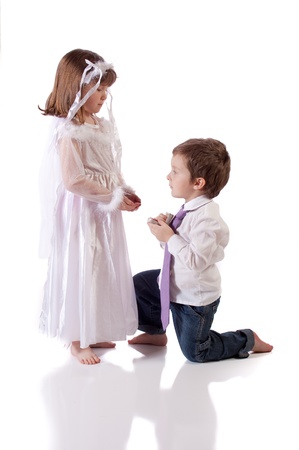 Cute little boy giving an engagement ring to a girlの写真素材