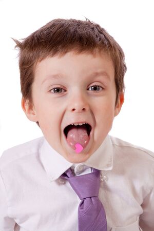 Cute little boy with a pink heart on his tongueの写真素材