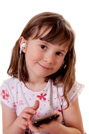 Cute little girl holding a mp3 player and listening to musicの写真素材