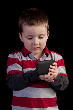 Cute little boy holding a portable video gameの写真素材