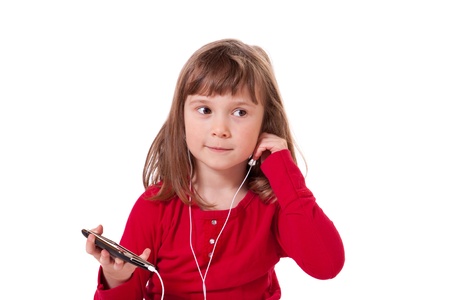 Cute little girl holding a mp3 player and listening to musicの写真素材