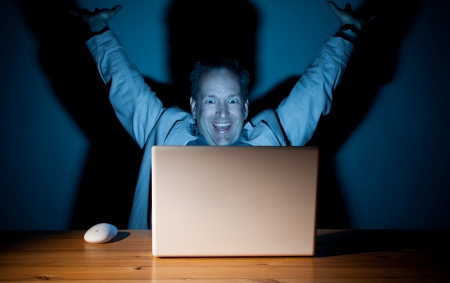 Man looking happy in front of his computerの写真素材