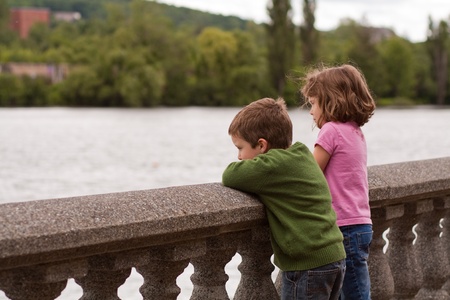 Cute little brother and sister looking at the riverの写真素材