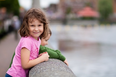 Cute little brother and sister looking at the riverの写真素材