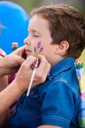 Cute little boy getting make-up on his faceの写真素材