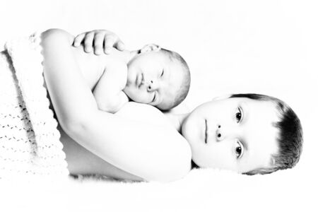 Newborn baby boy resting on his brotherの写真素材