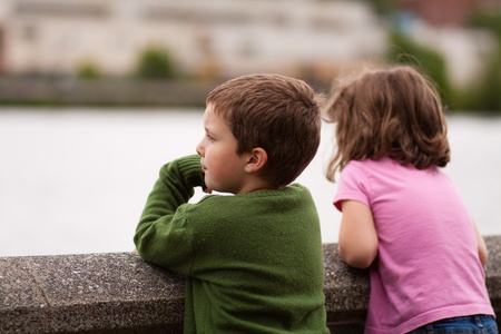 Cute little brother and sister looking at the riverの写真素材