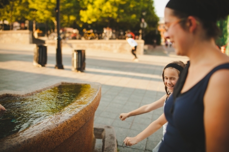 Mother and daughter laughing by a fountain in old Montrealの写真素材
