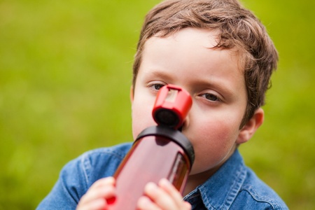 Boy drinking water on a summer dayの写真素材