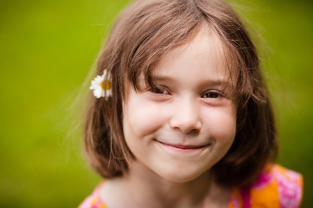 Girl smiling with a flower in her hairの写真素材