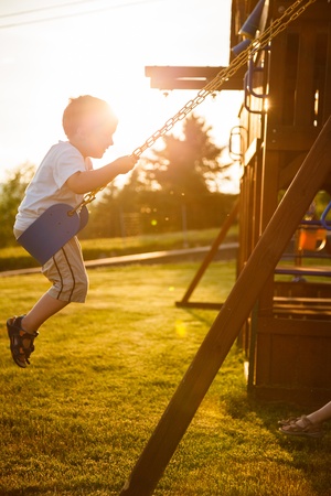 Boy on a swing in a playgroundの写真素材