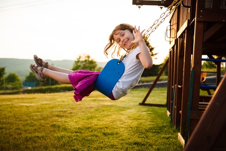 Little girl on a swing in a playgroundの写真素材