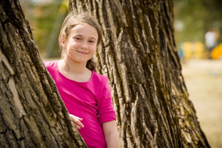 Young girl standing between two treesの写真素材