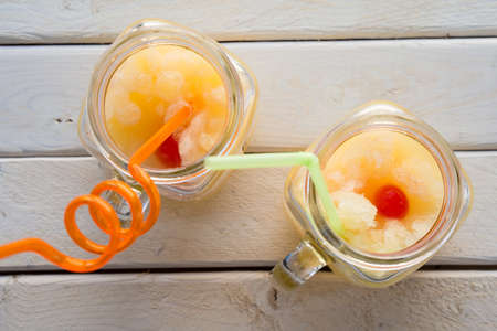 Homemade fruits slush in a jar with a strawの写真素材