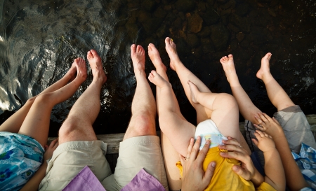 Family dipping their tows in water on a warm summer dayの写真素材