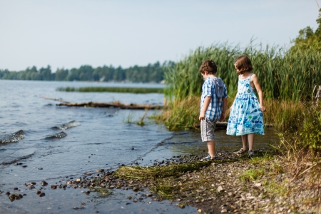 Brother and sister standing by a lake on a warm summer dayの写真素材