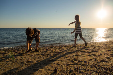 Children playing on the beach in Cape Cod at sunsetの写真素材