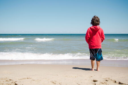 Boy standing on the beach and relaxing in Cape Codの写真素材