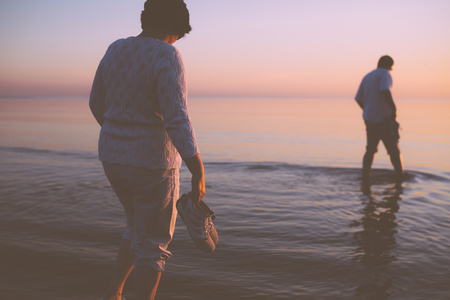 Senior couple strolling at sunsetの写真素材
