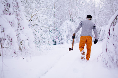 Lumberjack walks in a snowy forestの写真素材