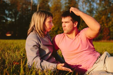 Young couple sitting on a meadowの写真素材